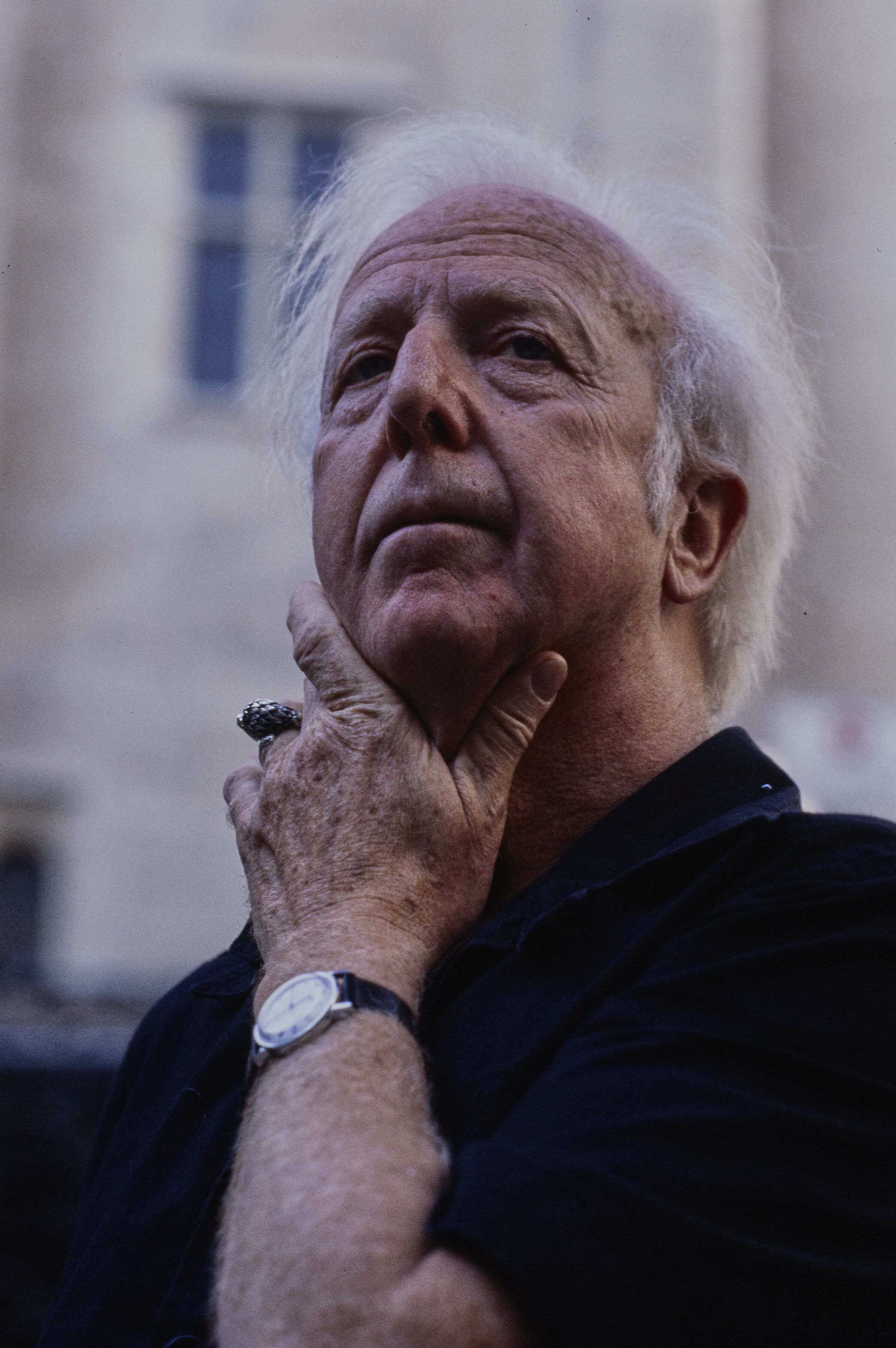 Close portrait of Alwin Nikolais with white hair, his hand resting under his chin.