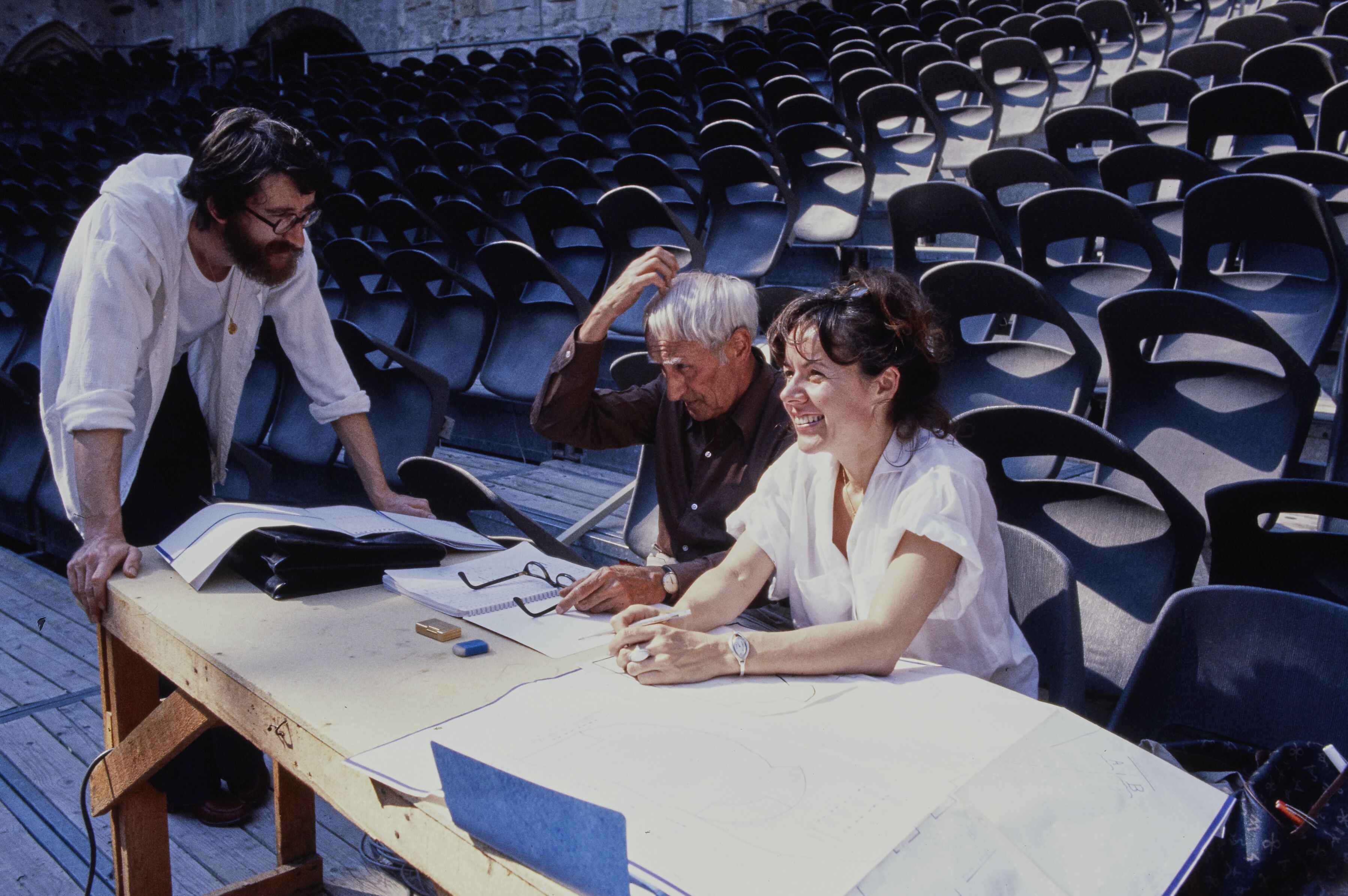 Alwin Nikolais seated between Pierre Saveron and Melly Puaux at an outdoor work table during the 1978 Festival d’Avignon.