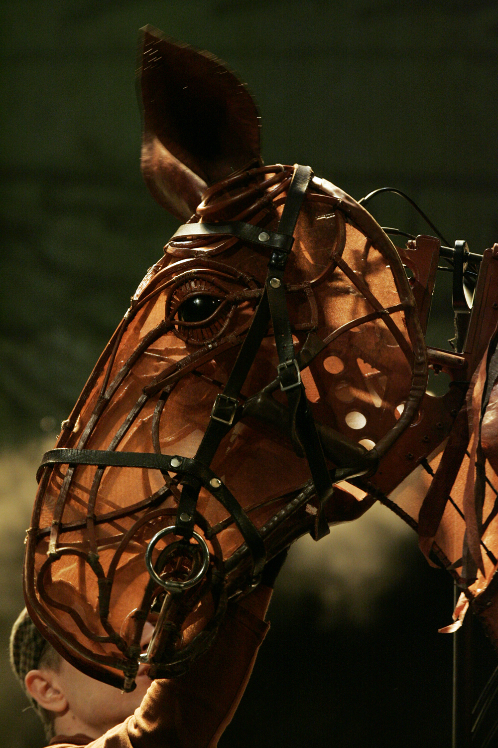 Close-up of the articulated head of a War Horse stage puppet under theatrical lighting
