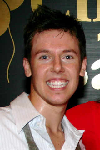 Portrait of Benji Schwimmer seated sideways in a blue sweater in 2007