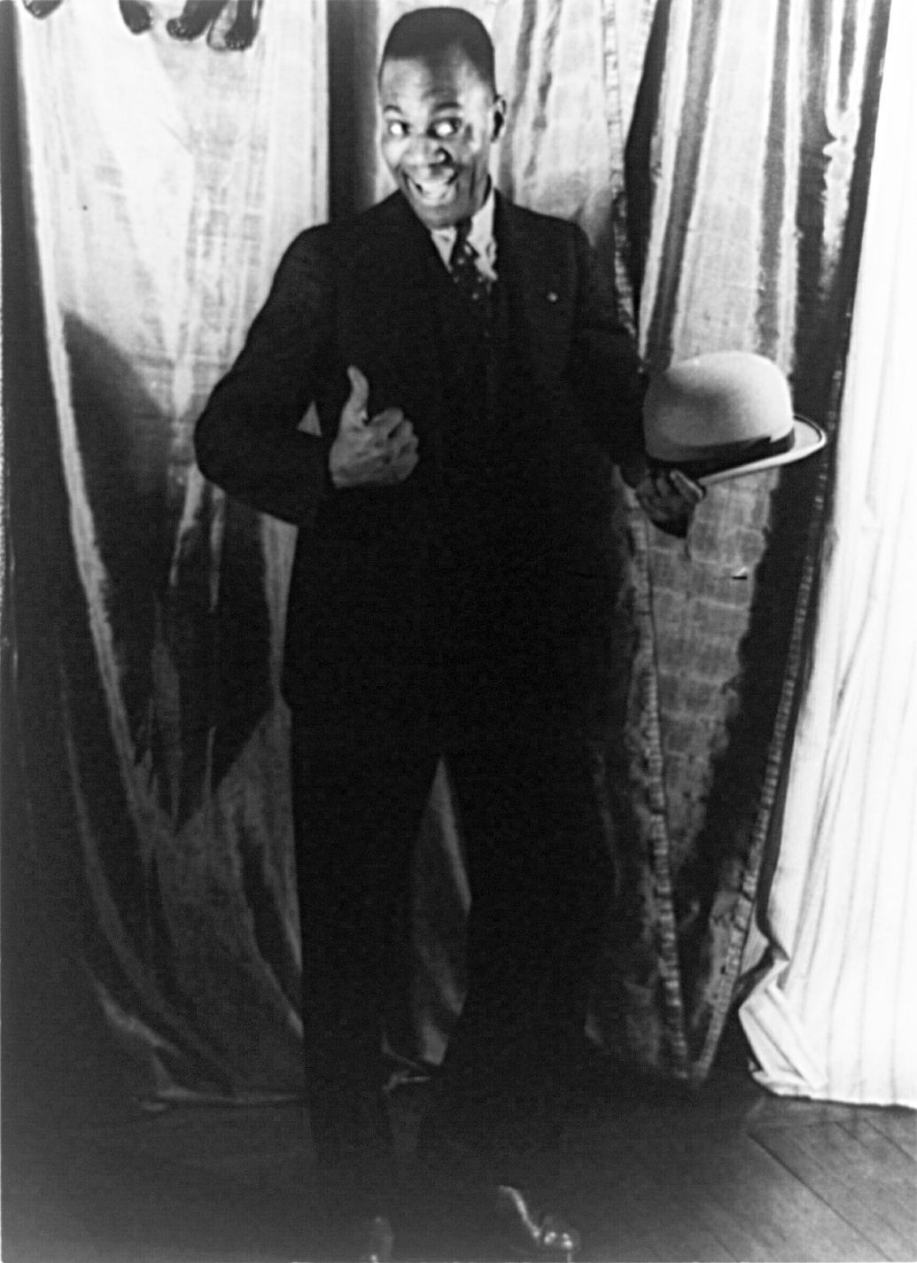 Formal portrait of Bill Bojangles Robinson seated in a suit in 1933