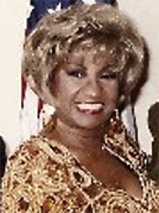 Celia Cruz smiling in a colorful stage costume in 1992