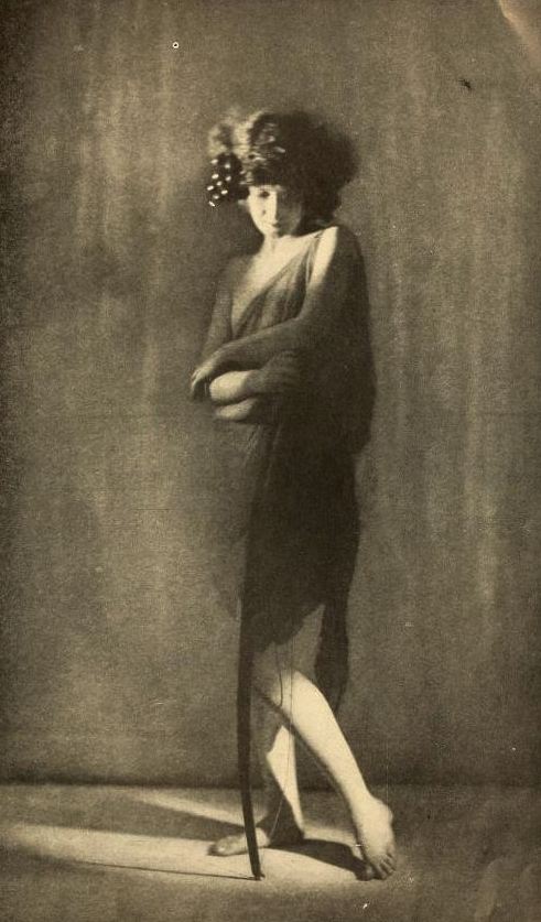 Doris Humphrey stands in a dark draped costume in a 1922 studio portrait.