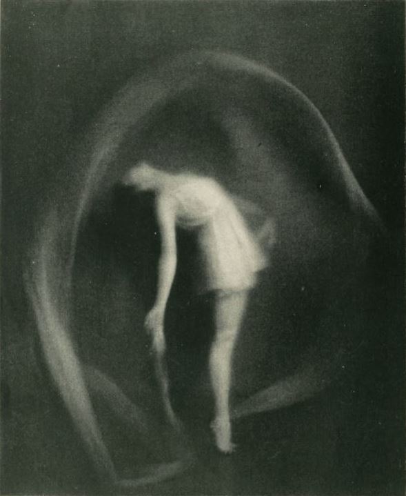 Doris Humphrey bends within a circular sweep of translucent fabric in The Scarf Dance.