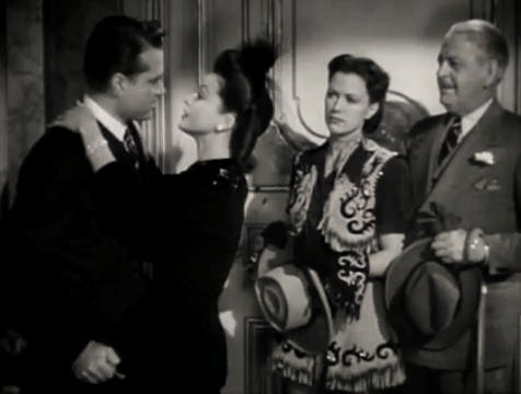 Cropped black-and-white trailer frame showing Red Skelton, Patricia Dane, Eleanor Powell, and Thurston Hall in I Dood It.