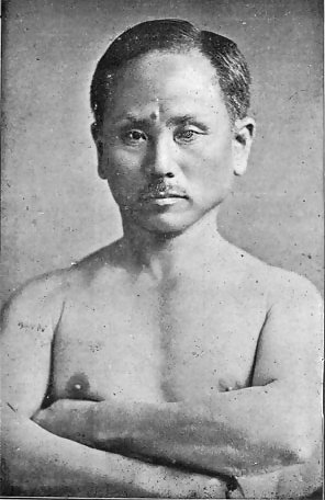 Black-and-white 1924 portrait of Gichin Funakoshi standing in karate attire