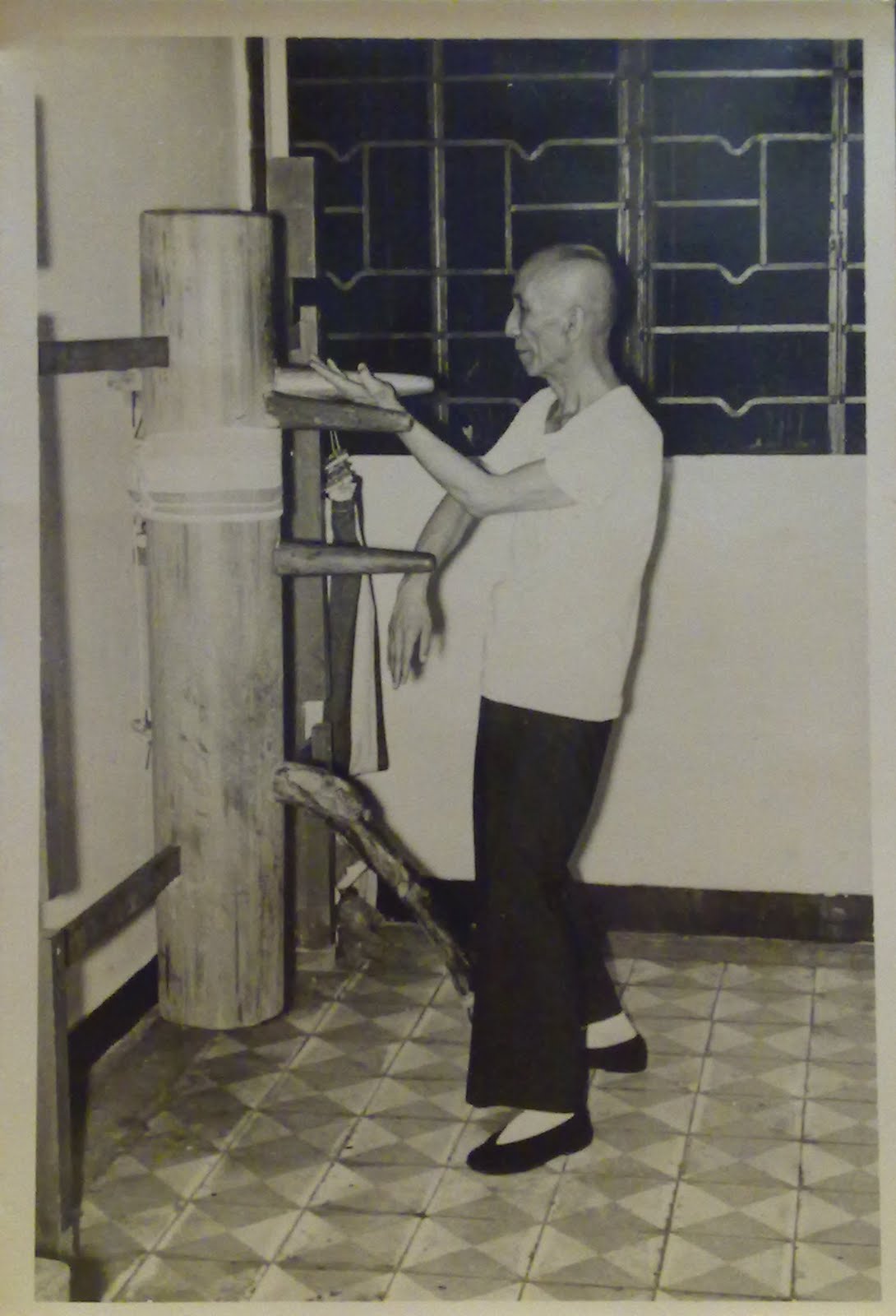 A Wing Chun practitioner working at a wooden dummy