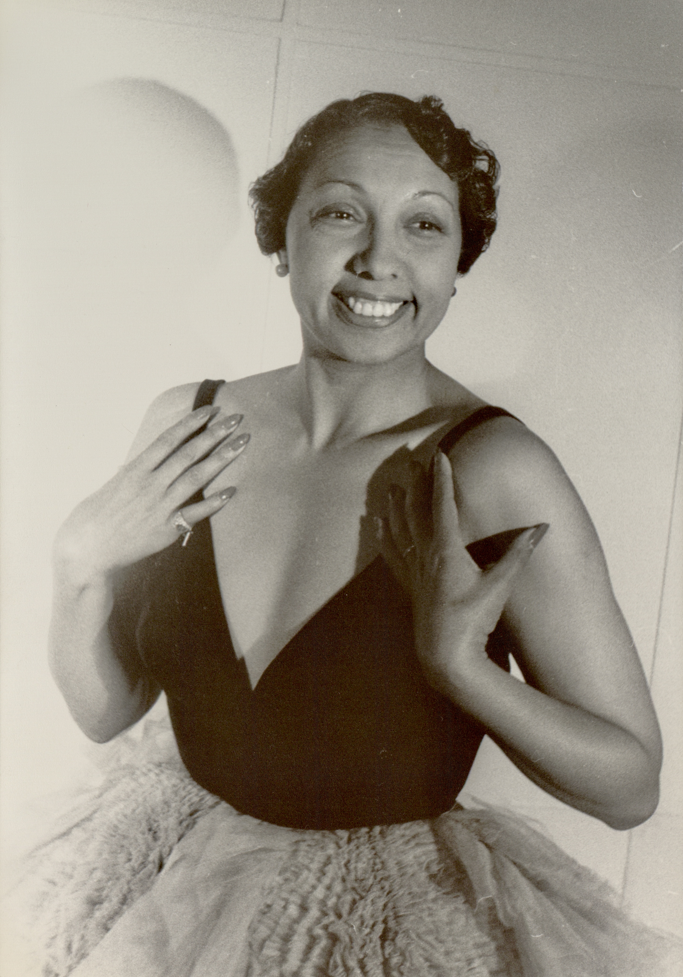 Studio portrait of Josephine Baker seated and looking toward the camera in 1949
