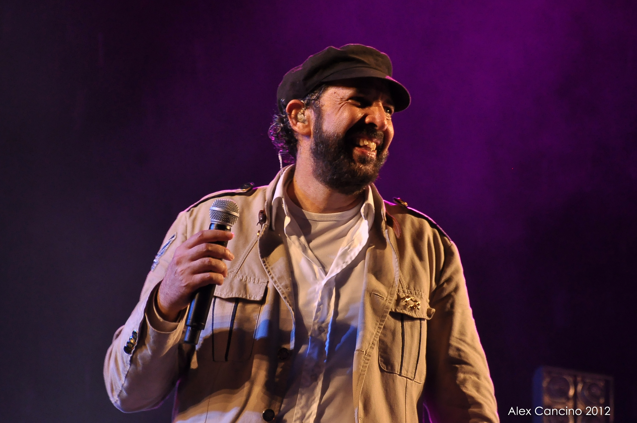 Juan Luis Guerra singing into a microphone at Santo Domingo's Estadio Olímpico in 2012