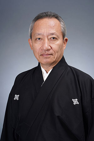 Kanjuro Kiritake III in a formal portrait, wearing dark traditional attire and facing the camera
