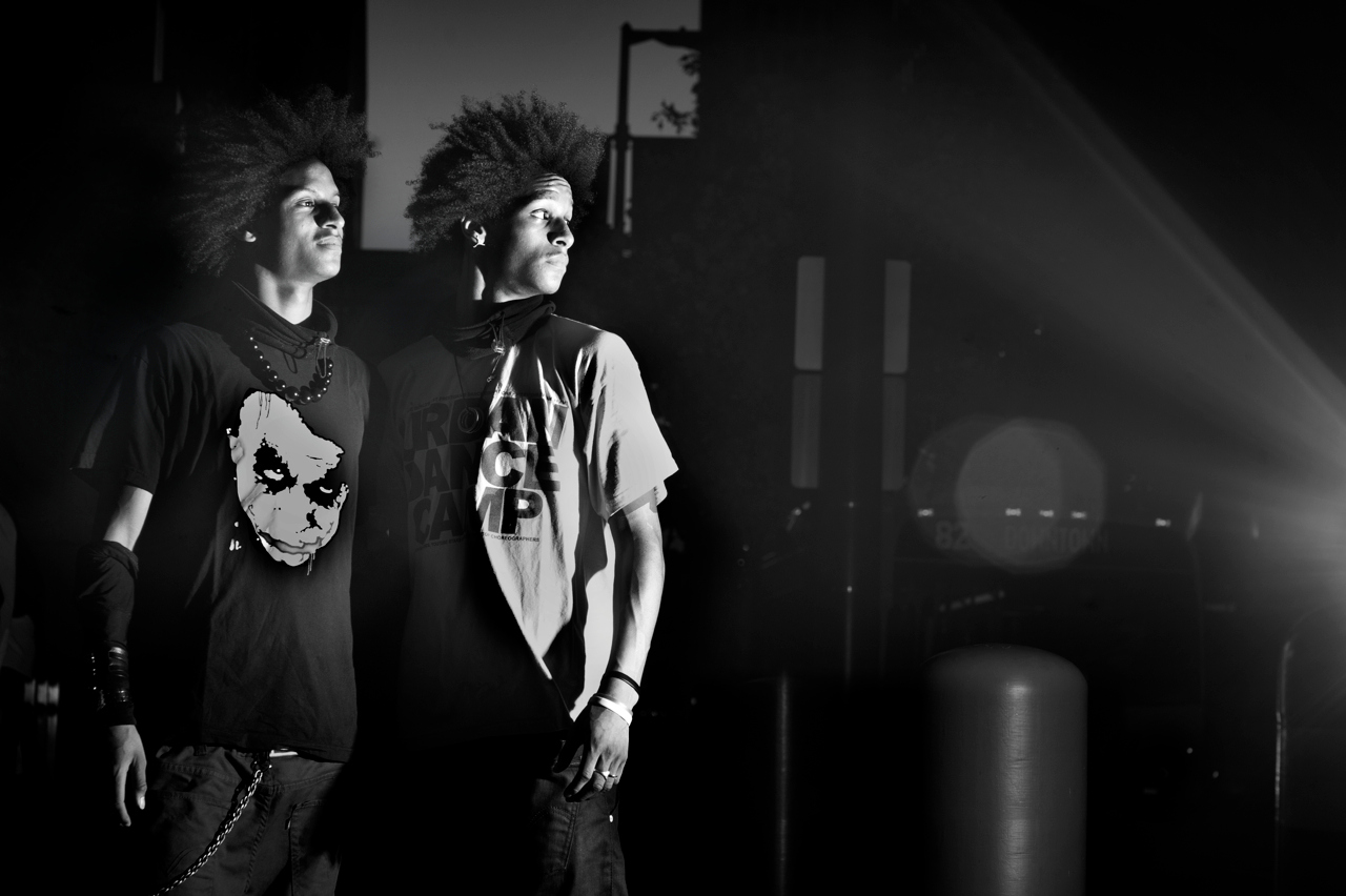 Les Twins standing under stage lighting at a World of Dance event