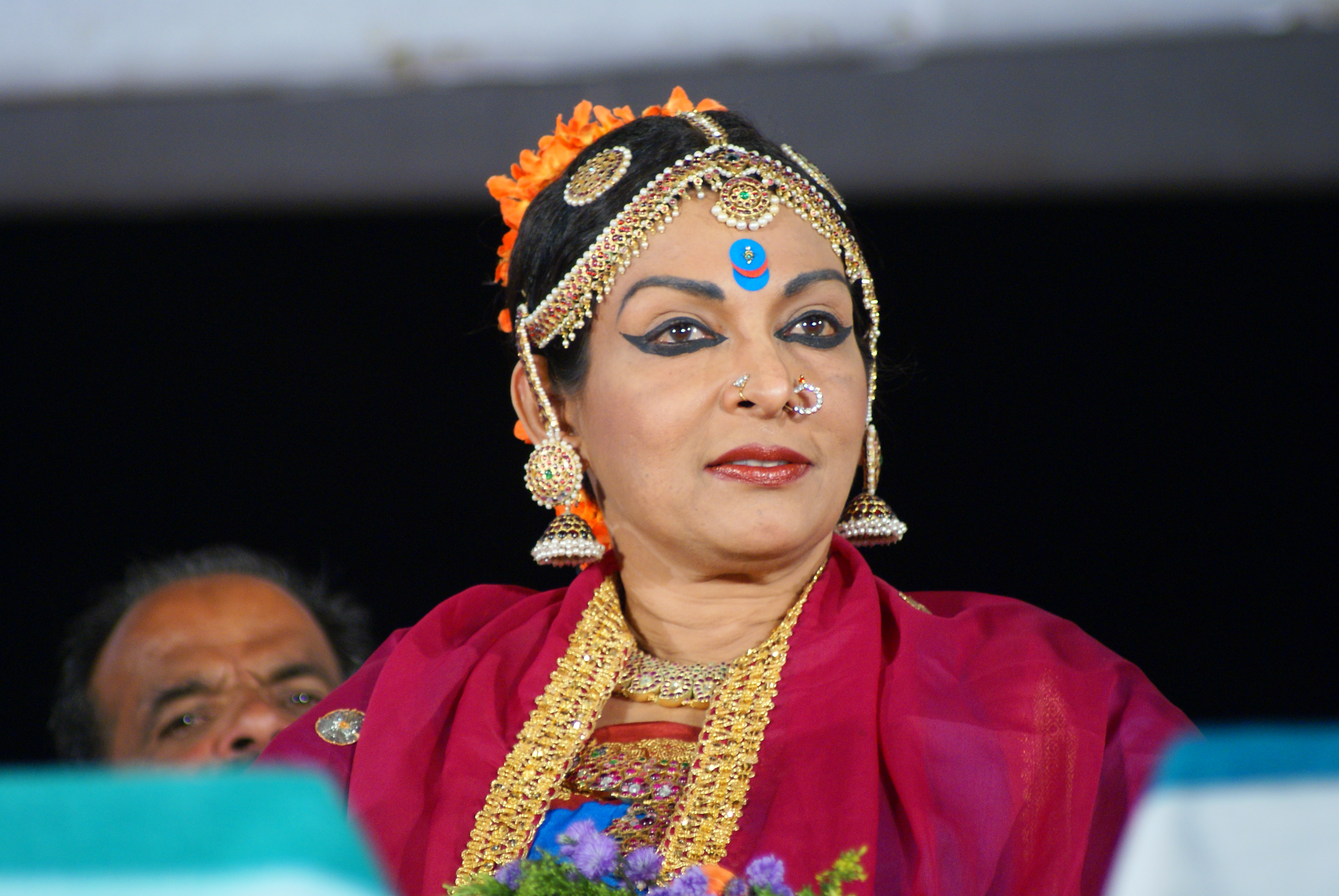 Mallika Sarabhai seated and speaking at an event in 2010