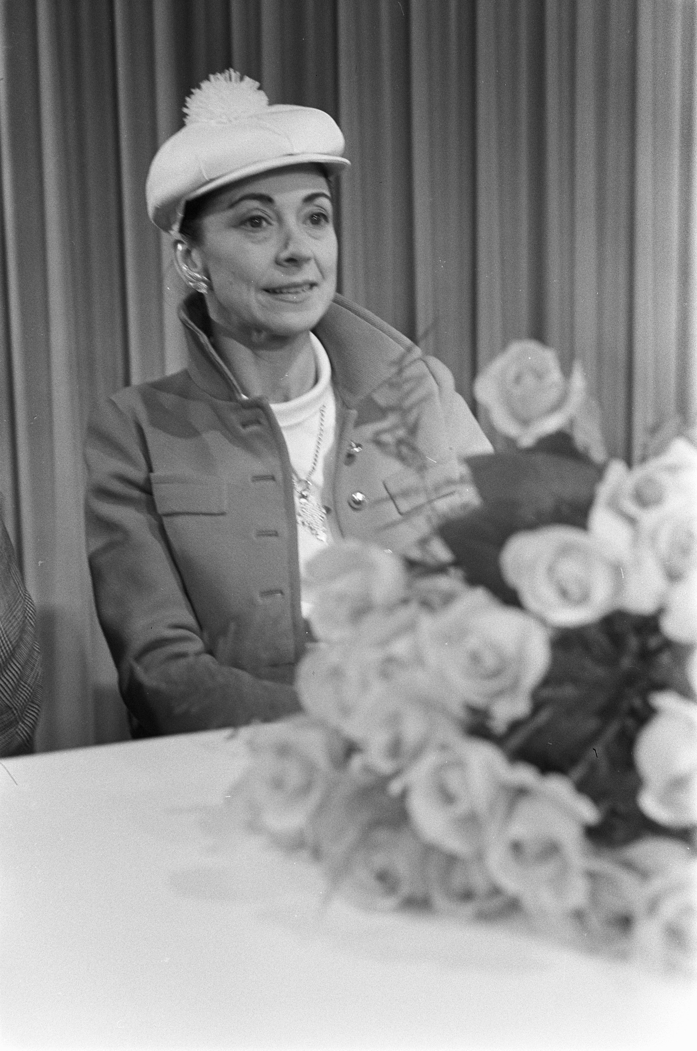 Margot Fonteyn seated with flowers after arriving at Schiphol Airport in 1968