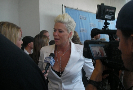 Mia Michaels in a white suit speaking during backstage interviews after the So You Think You Can Dance season four finale in 2008