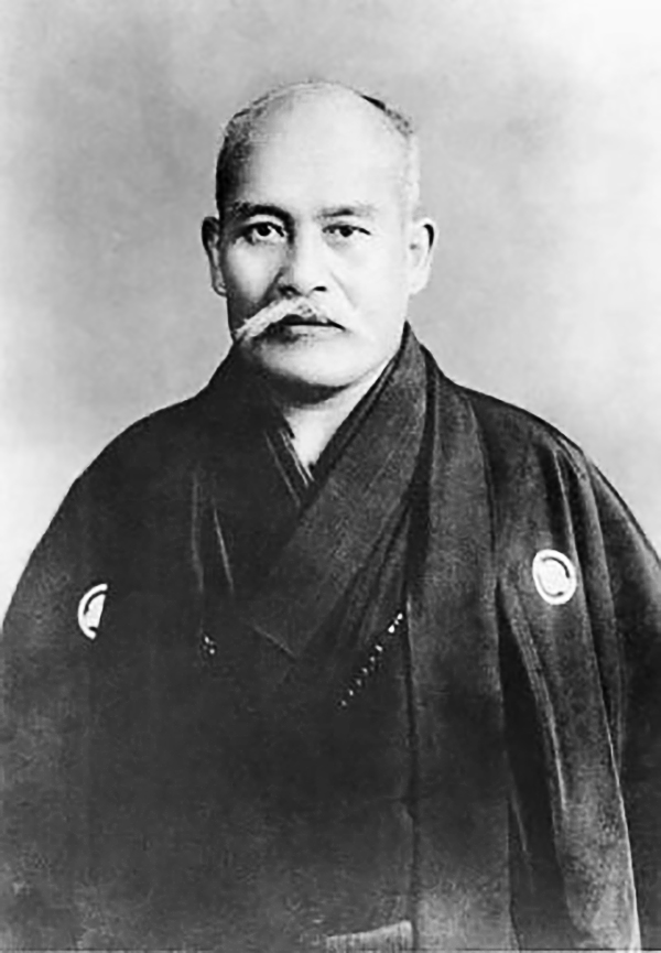 Black-and-white 1939 portrait of Morihei Ueshiba seated in traditional clothing.