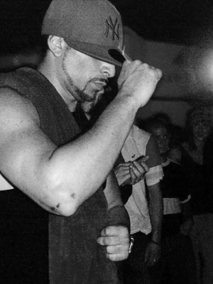 Black-and-white photograph of Mr. Wiggles dancing in a baseball cap at a 2005 event in Calgary.