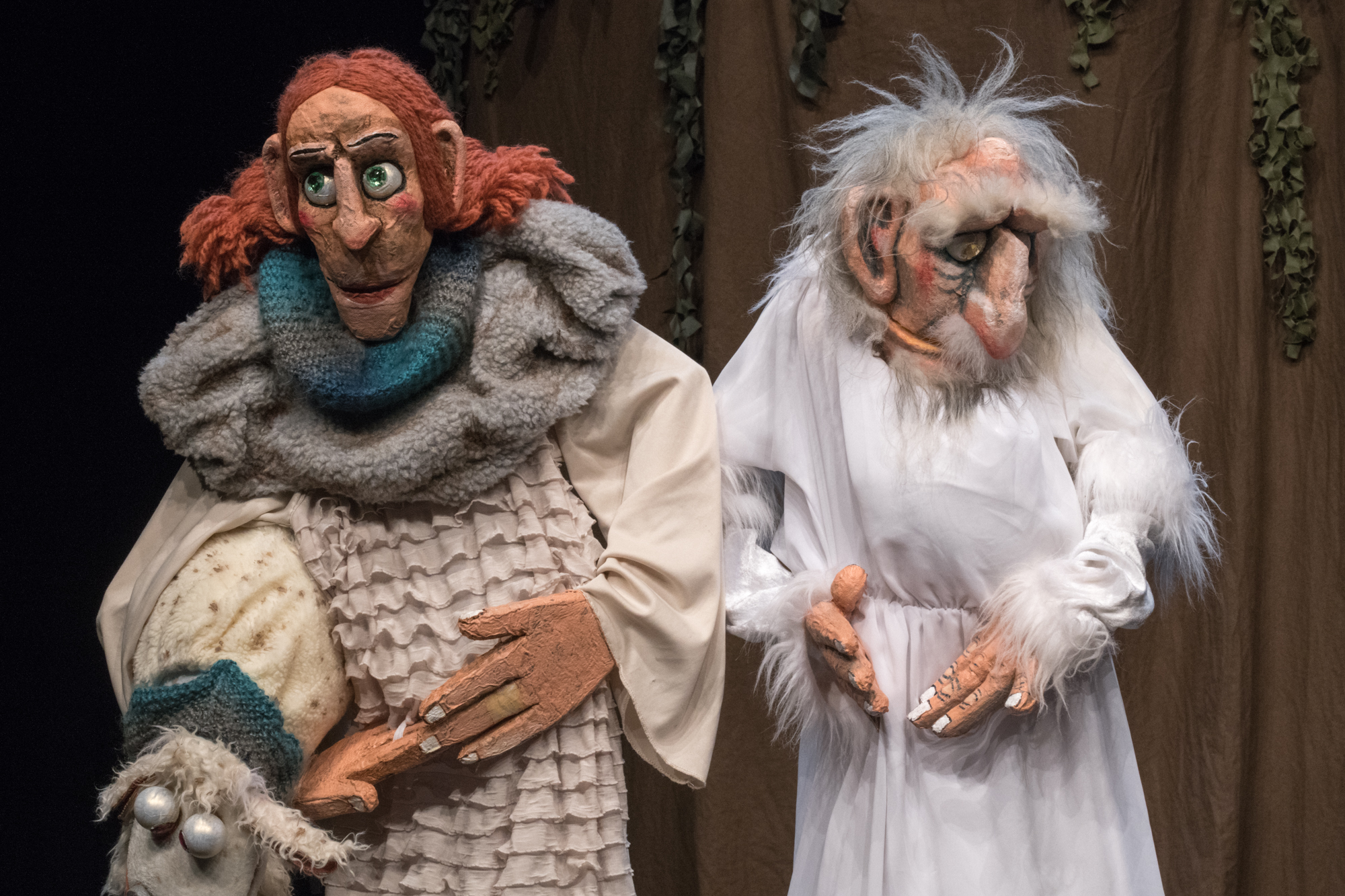 Neville Tranter performing Babylon among large expressive puppets on a dark stage