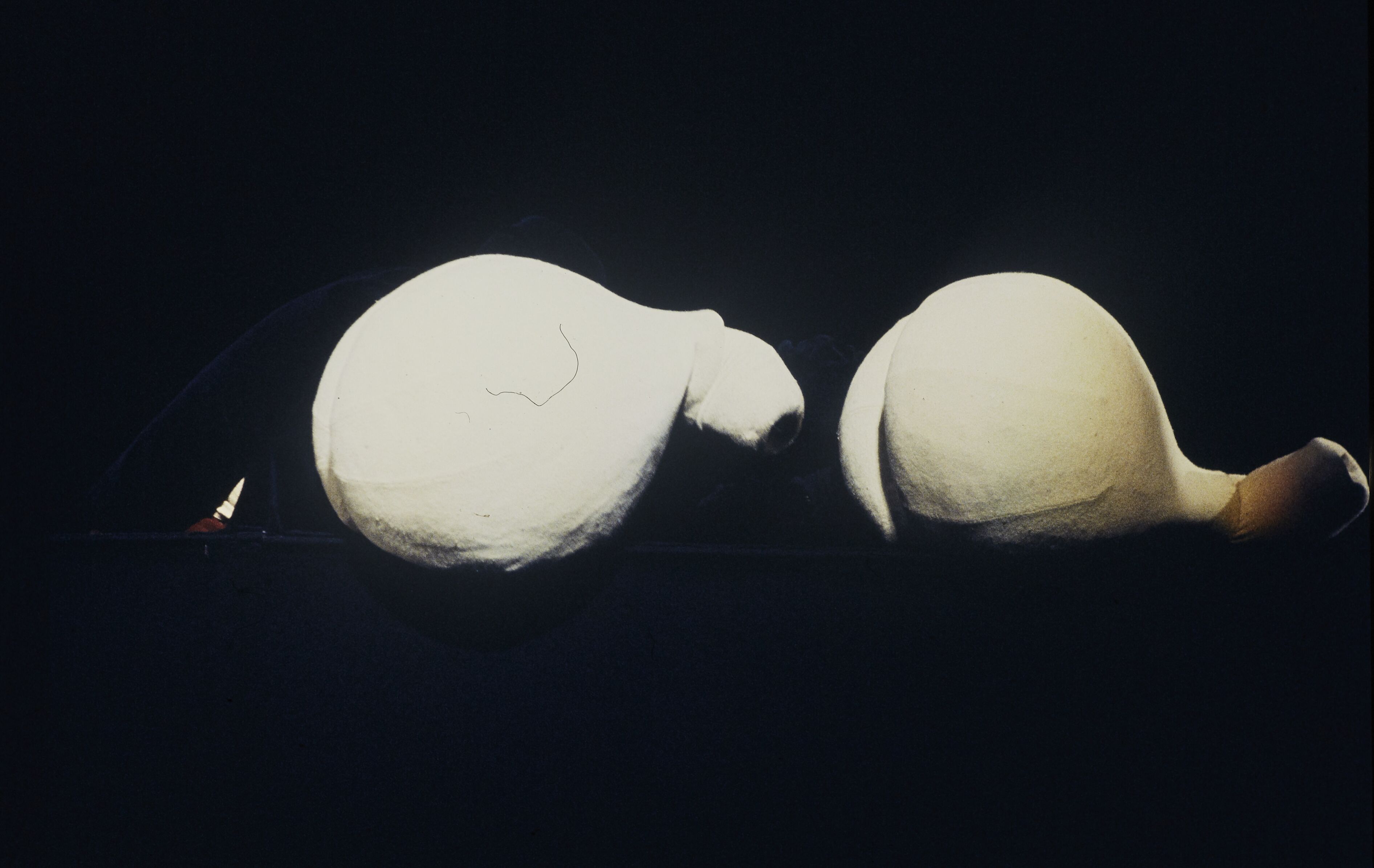 Two large pale rounded puppet-like forms on a black stage in a 1977 Compagnie Philippe Genty performance
