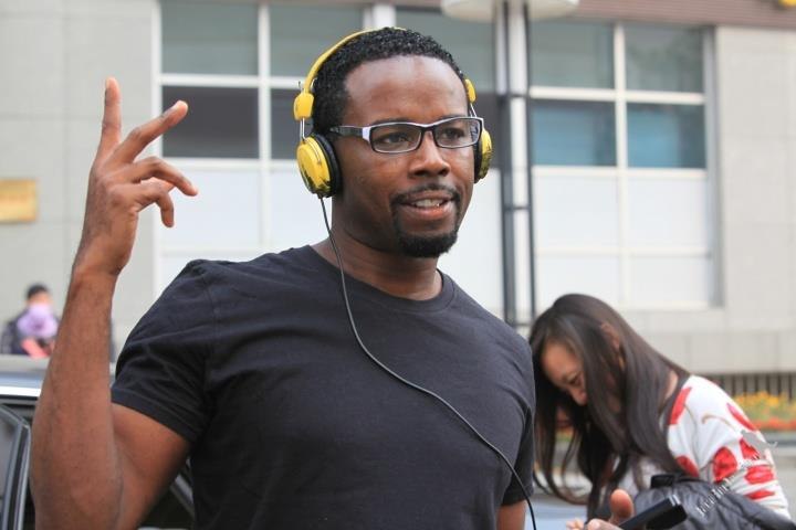 Popin’ Pete wearing glasses and yellow headphones at an outdoor event in March 2012.