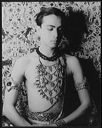 Black-and-white 1938 portrait of Ram Gopal wearing jewelry against a patterned backdrop