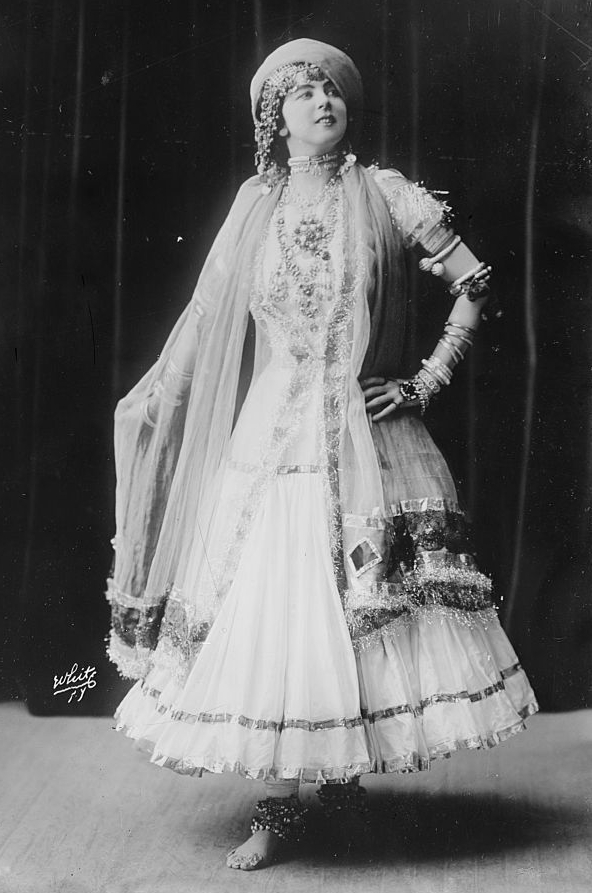 Full-length studio portrait of Ruth St. Denis in a decorated dance costume.