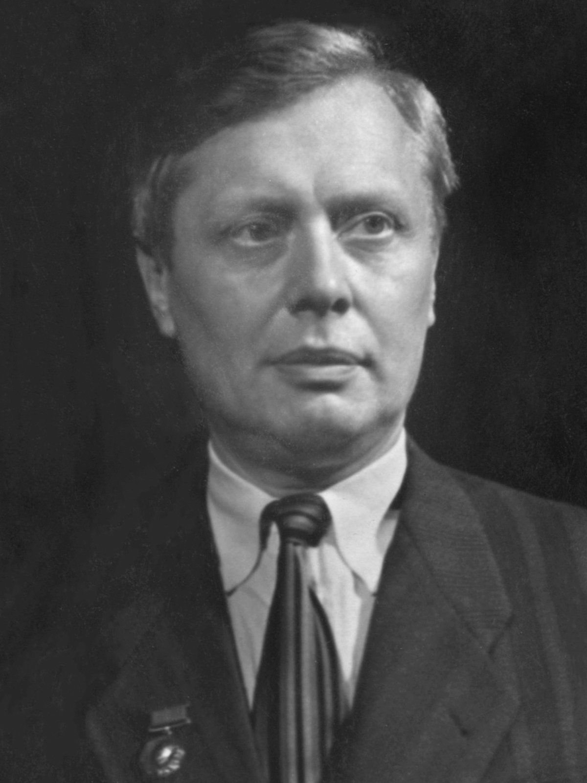 Sergei Obraztsov holding two expressive hand puppets in a 1951 black-and-white portrait