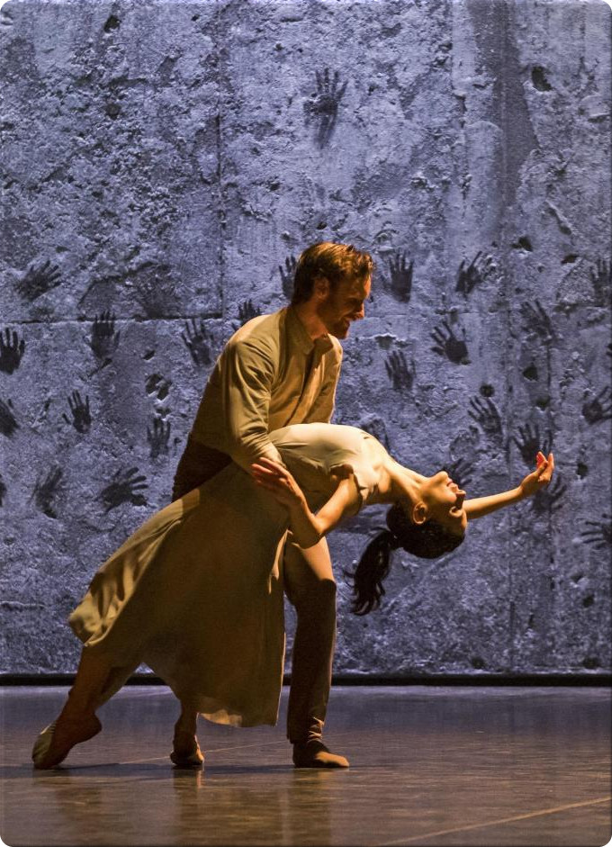 Tamara Rojo as Giselle in Akram Khan's Giselle, standing in a dark stage scene