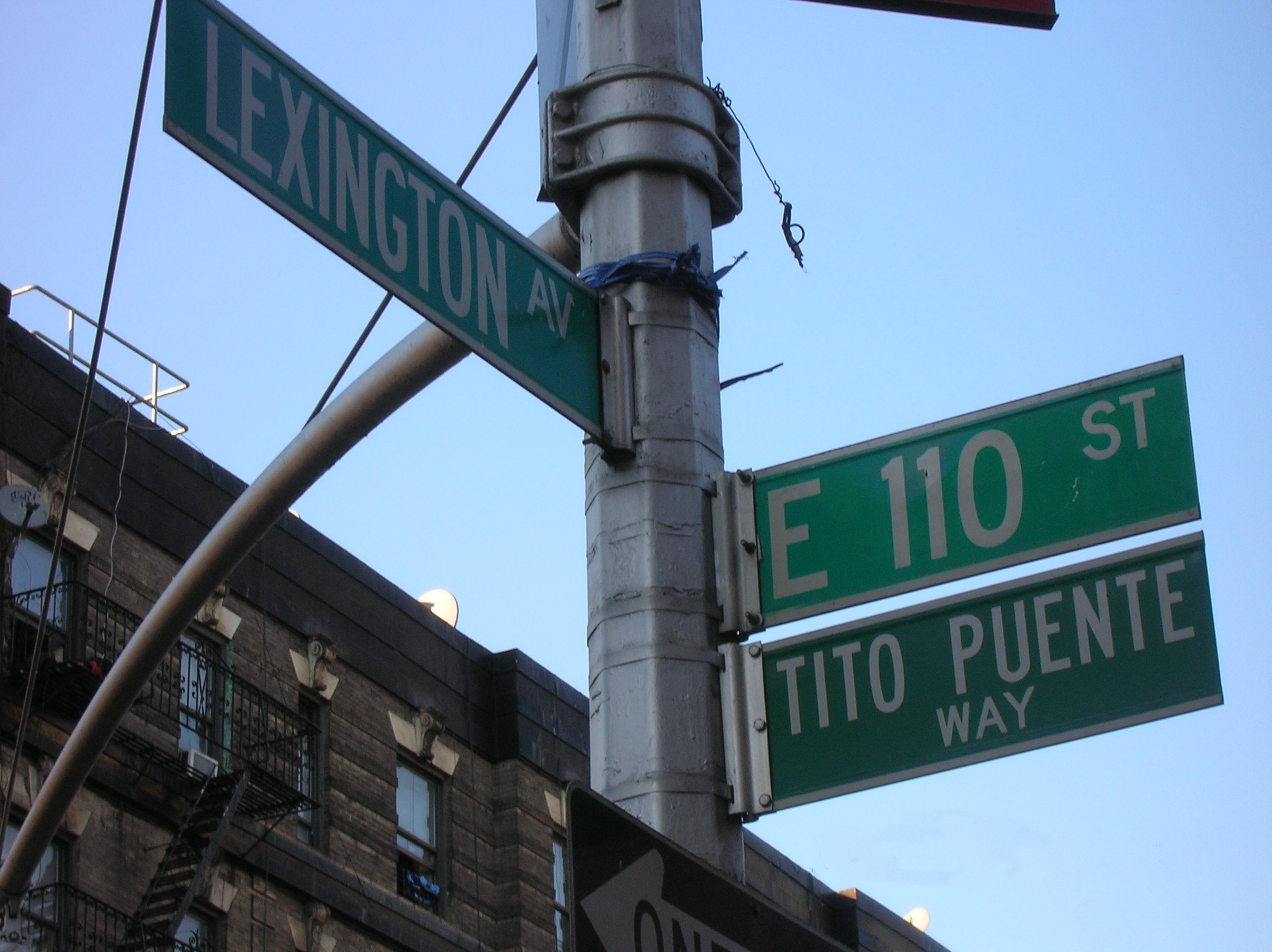 Green street sign reading Tito Puente Way at East 110th Street and Lexington Avenue in New York