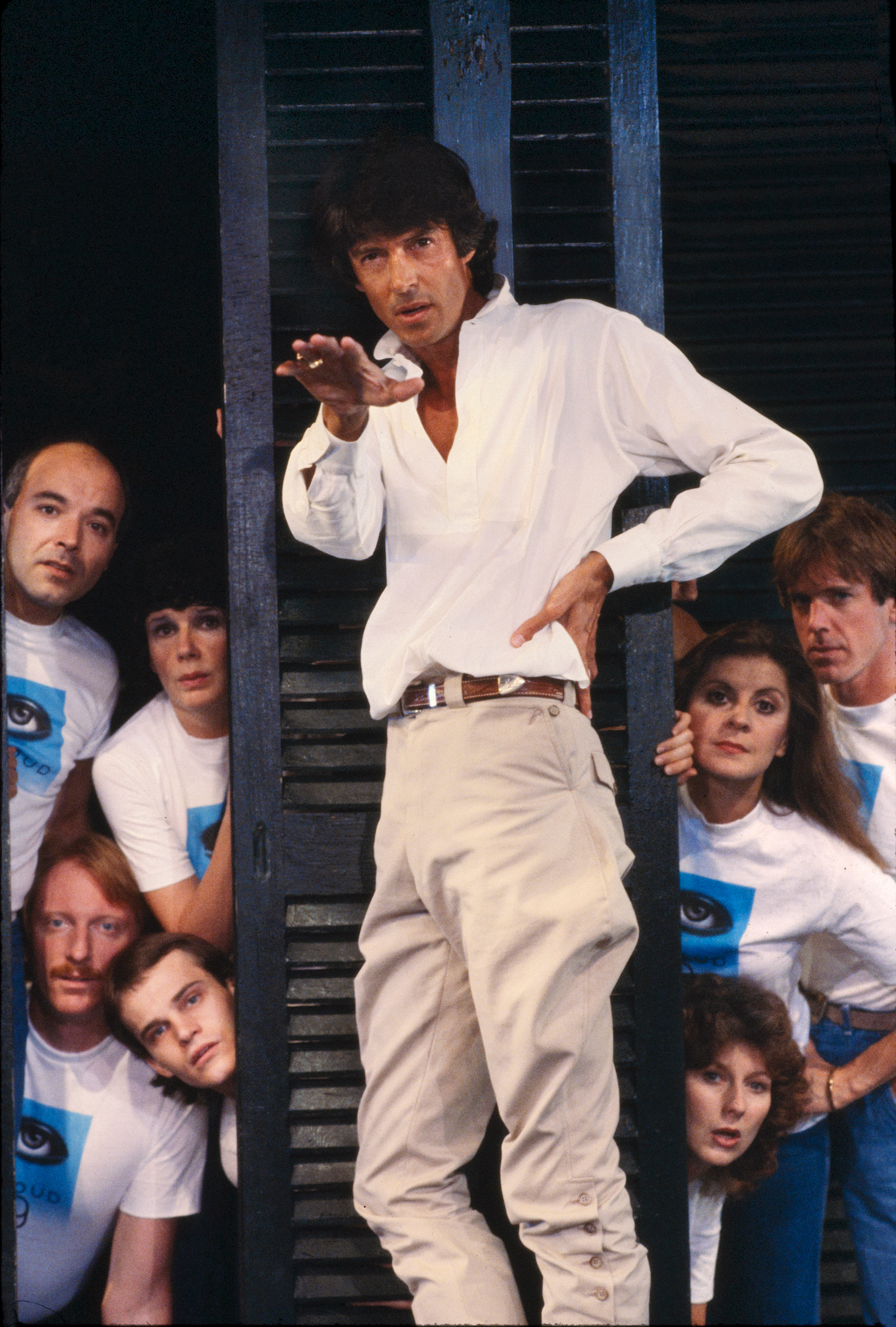 Tommy Tune stands and gestures while performers gather around him during a 1982 Cloud 9 rehearsal.