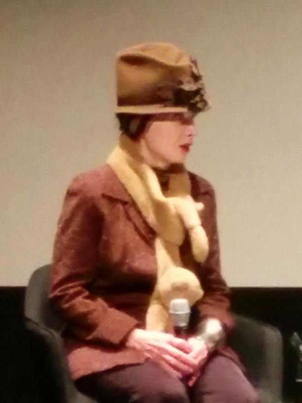 Toni Basil seated with a microphone at SFMOMA in 2016